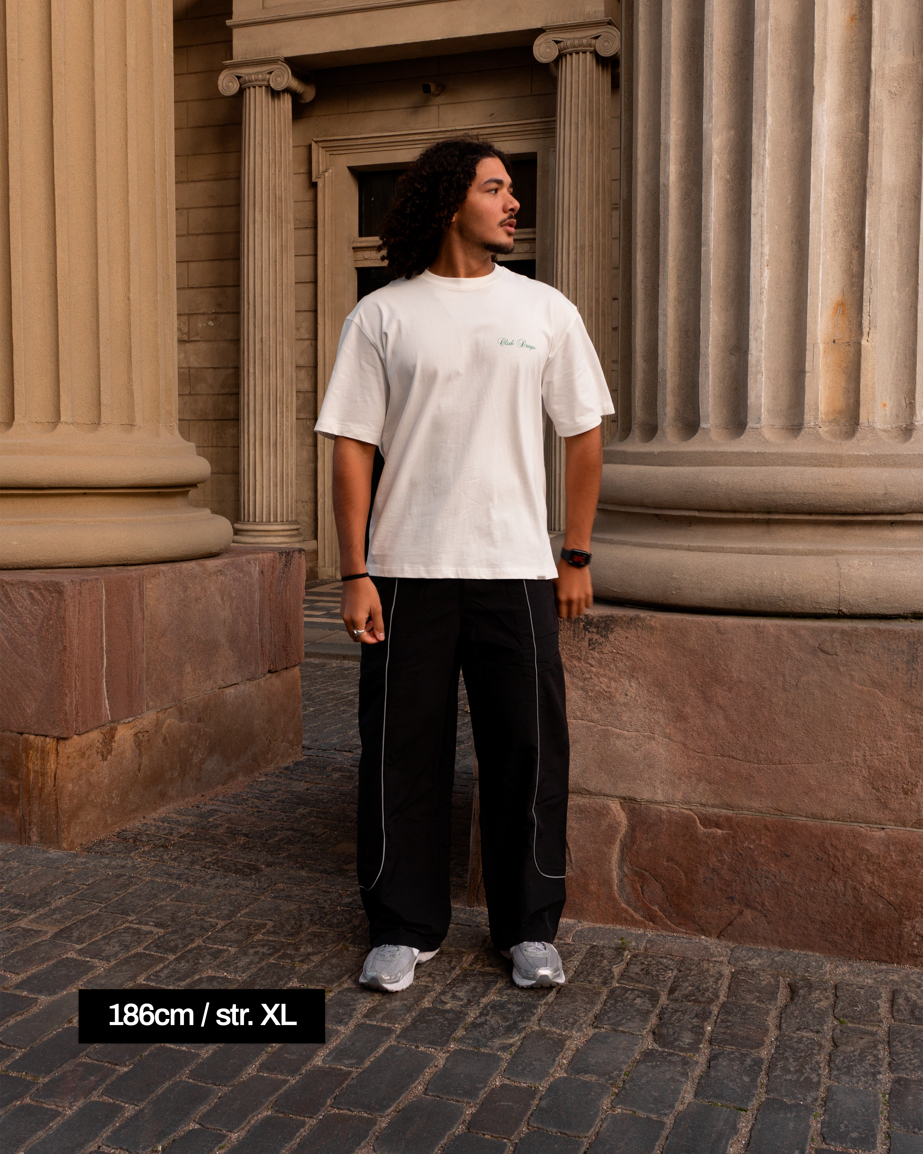 Ahmed i vores wide-fit Track Pants i Sort. Ahmed bruger størrelse XL for at få et afslappet moderne fit.